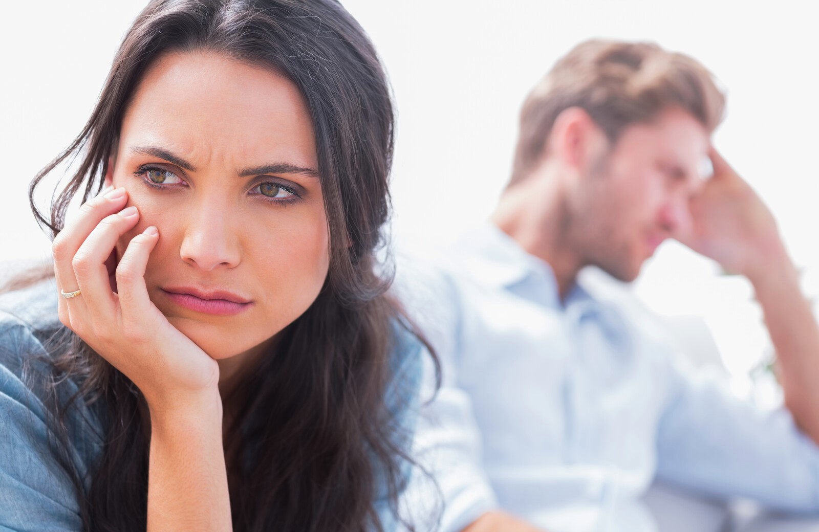 unhappy wife in foreground with husband in background