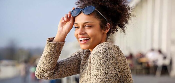 young woman smiling with sun on her face - concept of improving your life