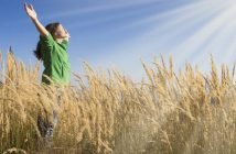 woman with arms in the air facing toward sun - illustrating spiritual goals