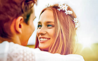 woman gazing lovingly at man whilst putting her arm around him