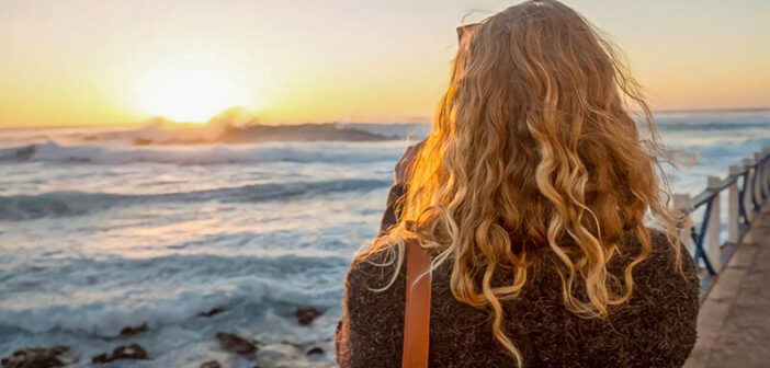 woman looking at sunrise over the ocean illustrating hope
