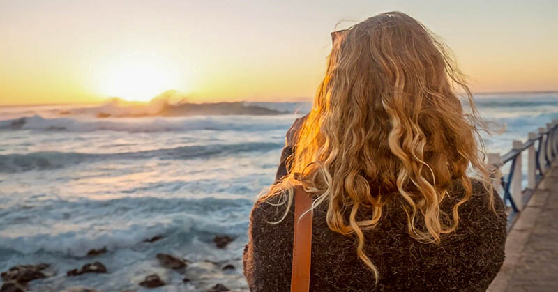 woman looking at sunrise over the ocean illustrating hope