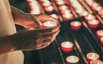 person lighting a candle for a dead loved one