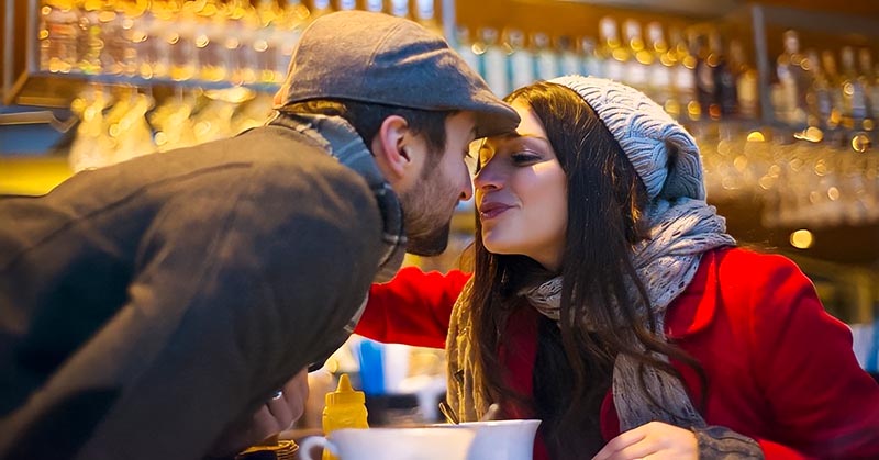 couple kissing in bar - illustrating falling in love too easily