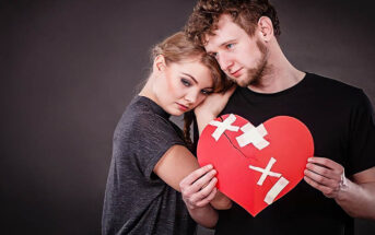couple holding a patched up red heart