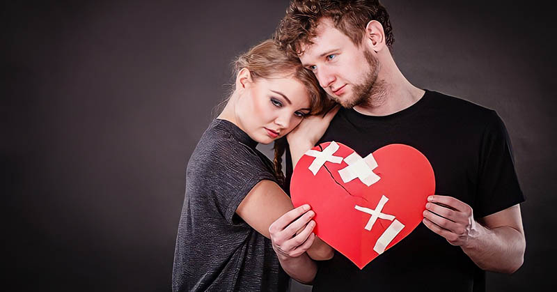 couple holding a patched up red heart