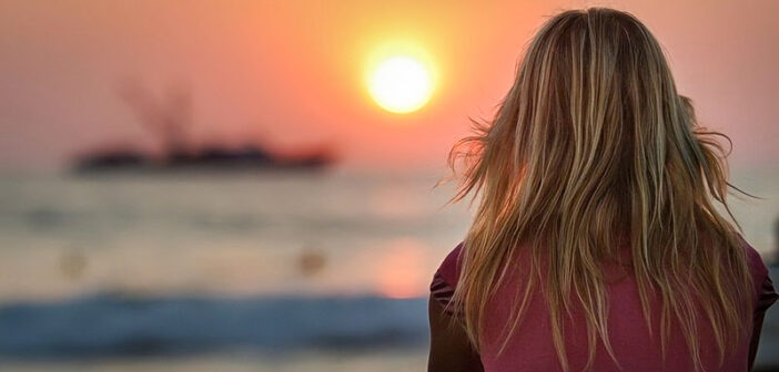 young woman facing sunset - illustrating finding inner peace