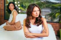 young woman with crossed arms turning her back on her friend because she's mad