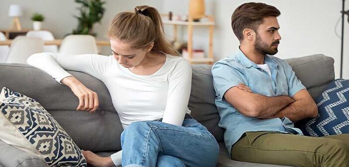 stubborn man with crossed arms facing away from despondent woman