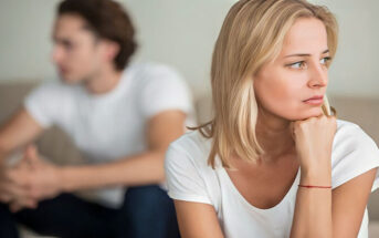 woman in foreground looking concerned and man in the background