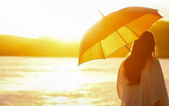 woman with sun umbrella looking at sun illustrating the aspects of life