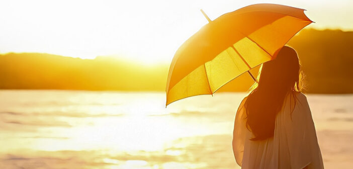 woman with sun umbrella looking at sun illustrating the aspects of life