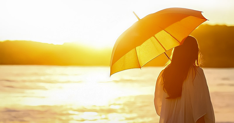 woman with sun umbrella looking at sun illustrating the aspects of life
