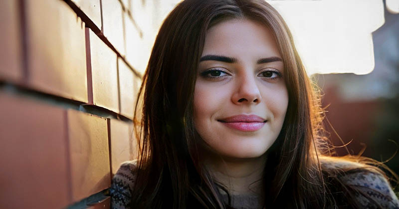 young woman smiling toward camera illustrating being a nice person