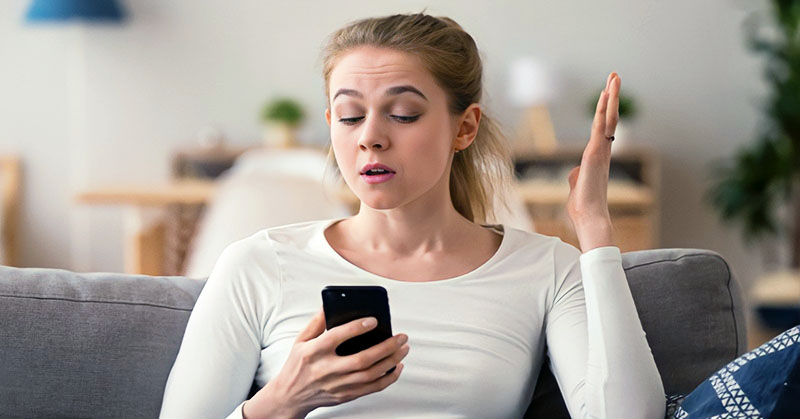 confused woman looking at phone after the guy who ghosted her got back in touch