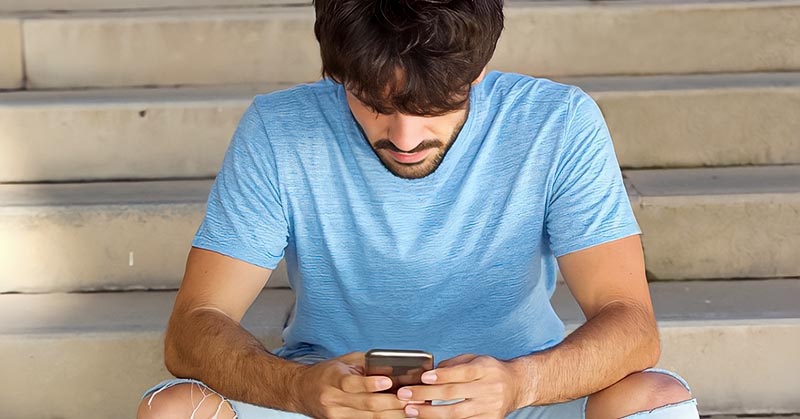 guy looking down at his phone illustrating that he likes to text but not call