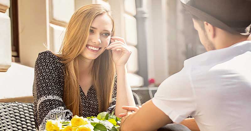 smiling woman looking at her boyfriend illustrating that he is serious about her