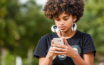 young African American woman texting a guy to ask him out on a date