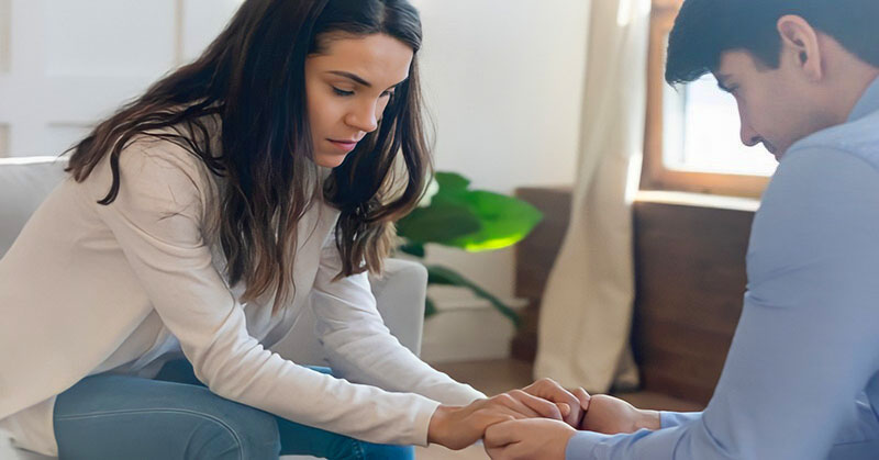 couple leaning toward each other holding hands to illustrate forgiving a cheater