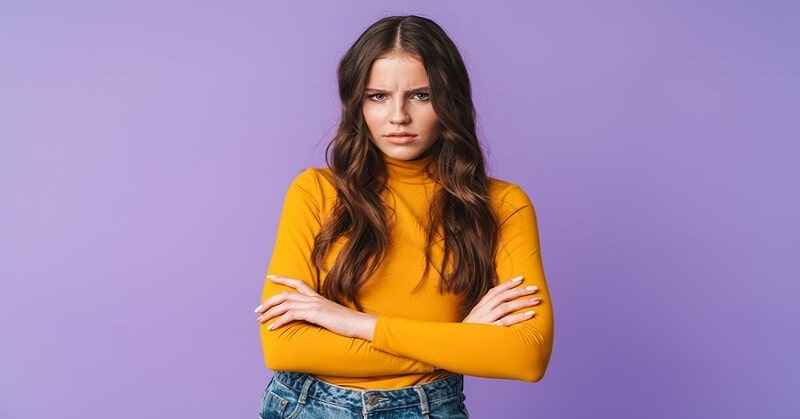 young woman with crossed arms looking offended by something or someone