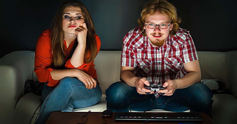 emotionally immature man playing video games and ignoring his girlfriend