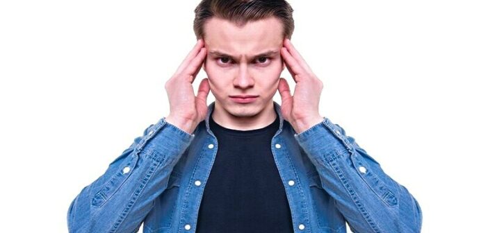 man with hands against temples of his head illustrating playing mind games