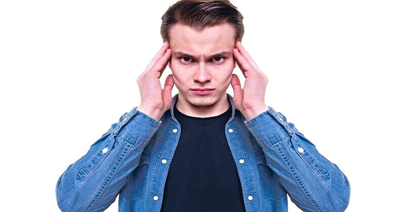 man with hands against temples of his head illustrating playing mind games