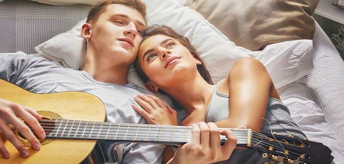 young couple relaxing on bed illustrating passing the 3-month mark in the relationship