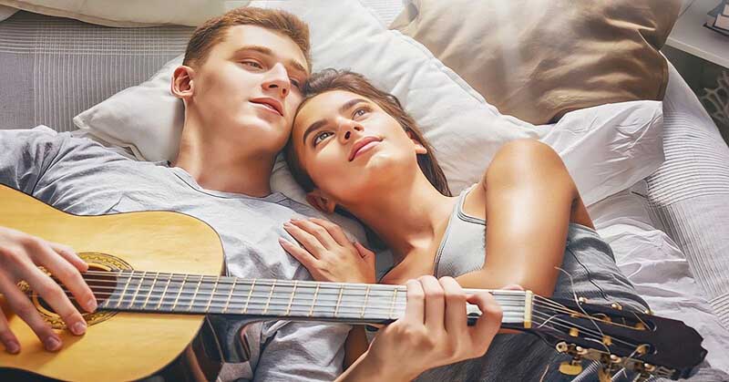 young couple relaxing on bed illustrating passing the 3-month mark in the relationship