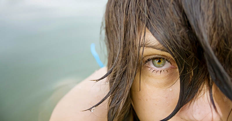 closeup of woman's face as she emerges from water