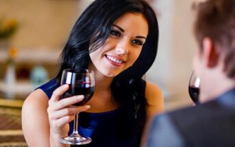 woman on first date with head tilted to one side indicating that it's going well