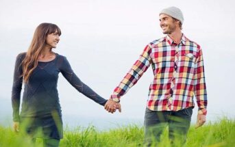 couple holding hands walking through grassy field illustrating patience in a relationship