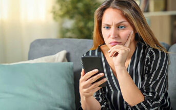 confused young woman staring at her phone wondering why he won't text first