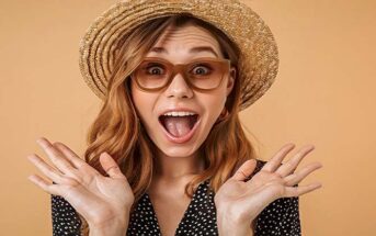 woman who looks excited with hands in the air illustrating an intense person