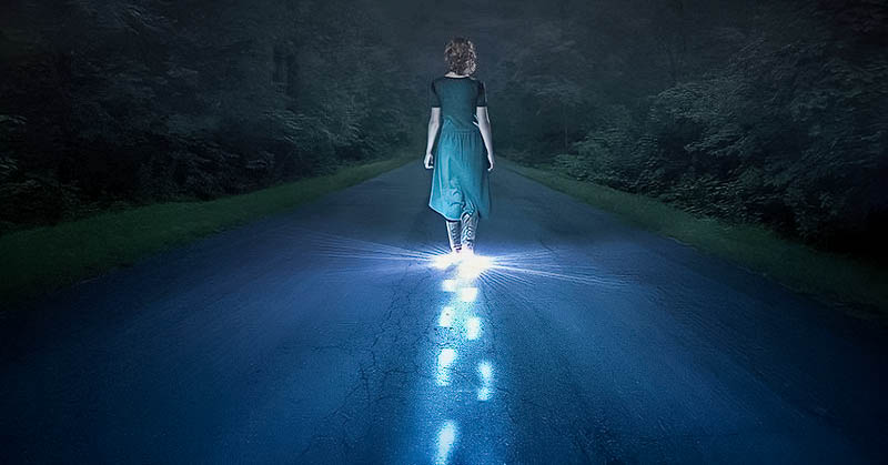 person walking in darkness with glowing footsteps of light - illustrating narcissistic abuse recovery