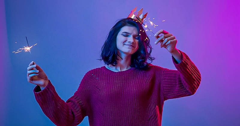 young woman with sparklers enjoying New Year's Eve alone