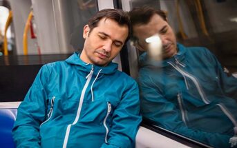 tired man asleep on train after work
