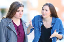 young woman being disrespectful to her friend in the street