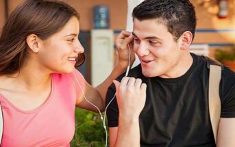 smiling young man and woman sharing headphone illustrating chemistry between people