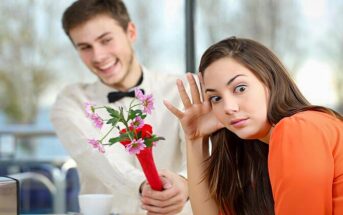 girl looking awkwardly away from a guy with flowers who is coming on too strong