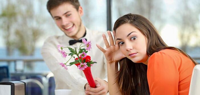 girl looking awkwardly away from a guy with flowers who is coming on too strong
