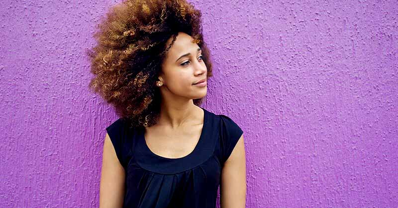 woman with a little smile on her face illustrating how to be positive