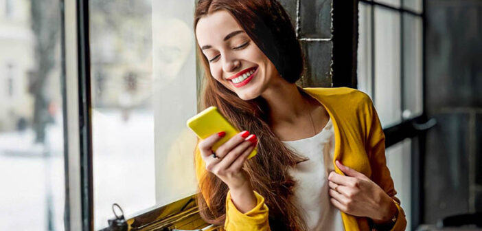 smiling woman looking at phone - illustrating texting too much before a first date