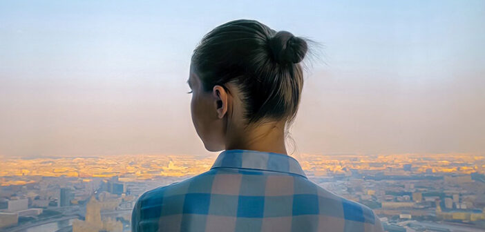young woman looking out over city feeling like she has no direction in life