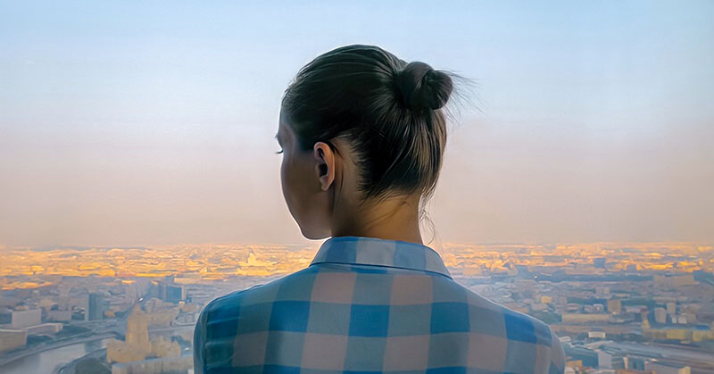 young woman looking out over city feeling like she has no direction in life
