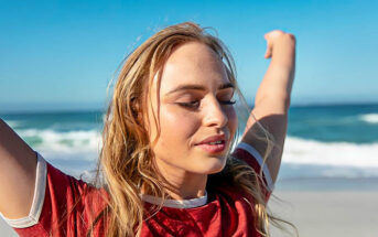 young woman feeling empowered with arms in the air