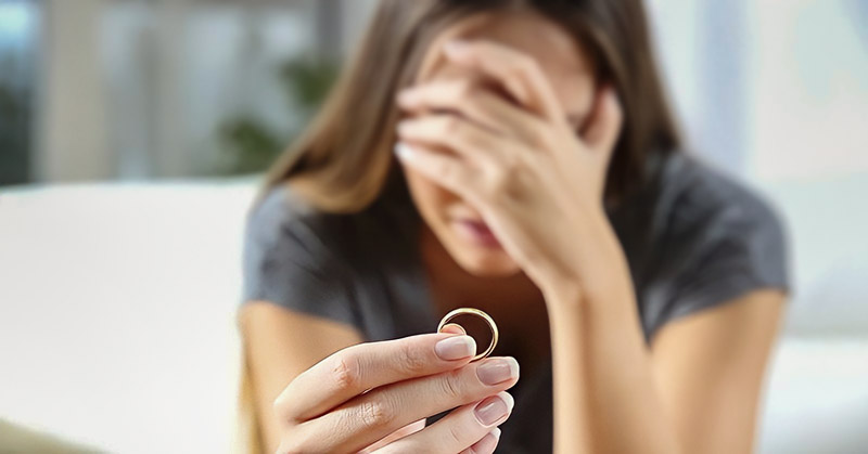 woman handing wedding ring back to her spouse after telling them she wants a divorce