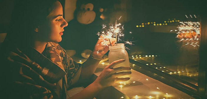 young woman lighting sparklers in a jar - illustrating appreciating what you have
