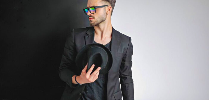 arrogant looking young man dressed in black with sunglasses and a hat - illustrating a bad boy
