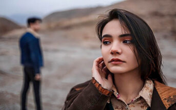 anxious woman in foreground with guy in the background - illustrating hot and cold behavior